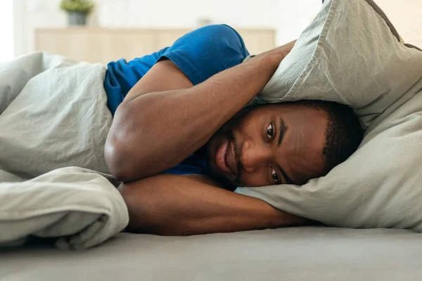 African American Man Having Insomnia Covering Ears Pillow Looking Camera — Foto de Stock