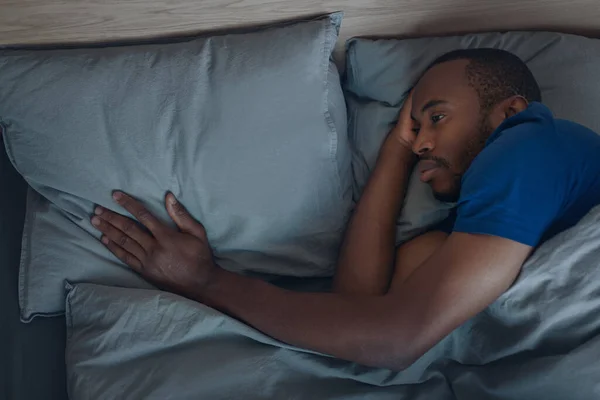 Unhappy Black Man Touching Pillow Lying Bed Mourning Suffering Loss —  Fotos de Stock