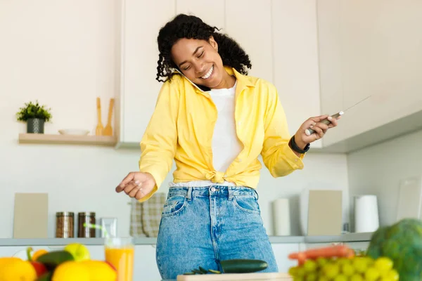 Cheerful Young Black Woman Talking Cellphone Holding Knife Hand Cutting — 스톡 사진