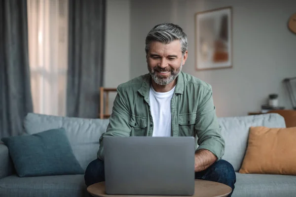 Cheerful Retired European Male Beard Blogger Typing Computer Watching Video — Stockfoto