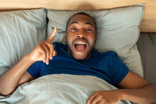 Ενθουσιασμένος Αφροαμερικανός Που Έχει Την Ιδέα Ξαπλωμένος Στο Κρεβάτι Δείχνοντας — Φωτογραφία Αρχείου