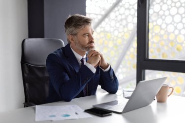 Entrepreneurship Concept. Portrait Of Pensive Handsome Middle Aged Businessman Sitting At Workplace In Office, Thoughtful Mature Entrepreneur Working At Desk With Laptop Computer, Copy Space