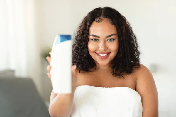 Happy African American Oversize Woman Showing Shower Gel Bottle Advertising — Stockfoto