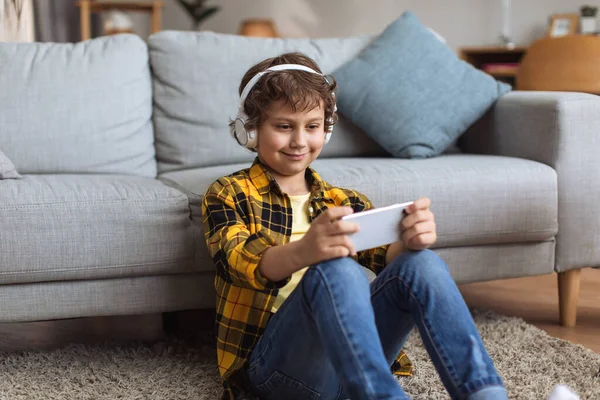 Cute Little Boy Wearing Headphones Watching Video Streaming Smartphone Sitting —  Fotos de Stock