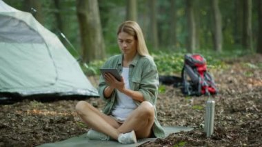 Internet anywhere. Pretty middle aged woman tourist web surfing online on digital tablet, enjoying camping rest on nature, slow motion, free space