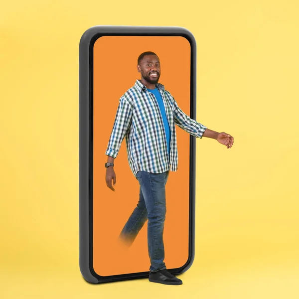 Cheerful Black Guy Stepping Out Huge Smartphone Screen Walking Yellow — 图库照片