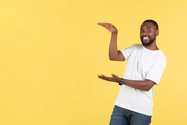 Look Cheerful African American Male Showing Invisible Product Holding Hands — Foto de Stock