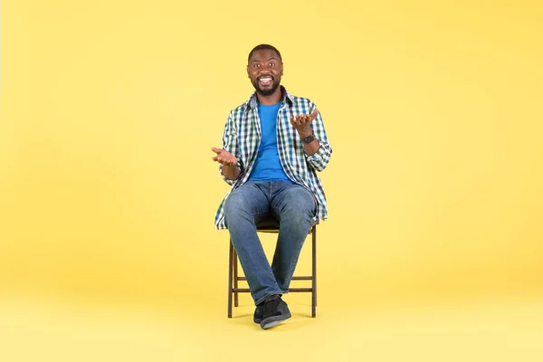 Happy African American Male Talking Looking Camera Sitting Chair Yellow — Fotografia de Stock