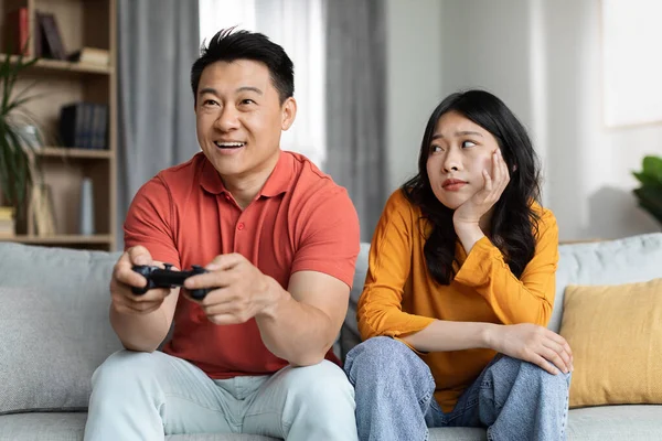 Bored Young Asian Woman Sitting Couch Her Happy Boyfriend Playing — Fotografia de Stock