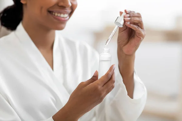 Smiling Young Black Woman Using Moisturizing Serum While Making Beauty — Stock fotografie