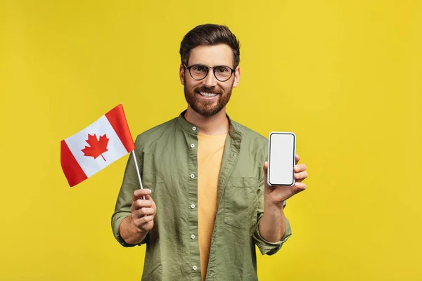 Online Learning Concept Happy Man Holding Smartphone Canada Flag Recommending — Stock fotografie
