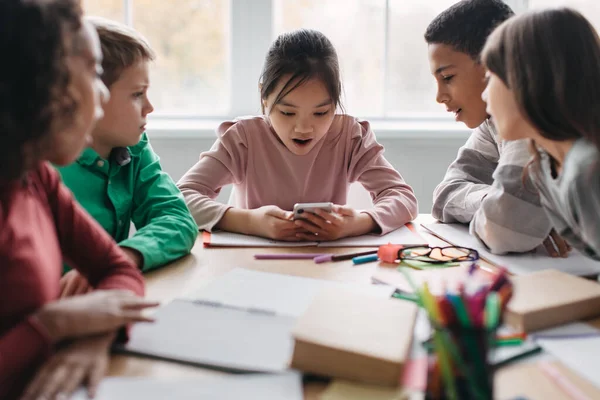 Amazed Diverse Classmates Using Smartphone Sitting Desk Together Break Modern — Stockfoto