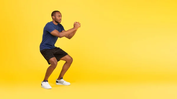 Sporty Black Guy Exercising Doing Deep Squats Training Looking Aside — Stok fotoğraf