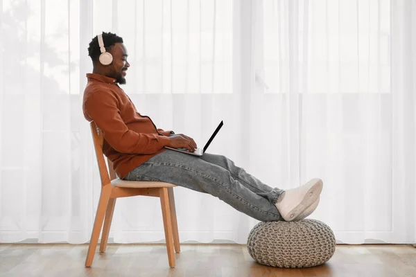 African American Male Freelancer Using Laptop Computer Wearing Earphones Working — Stockfoto