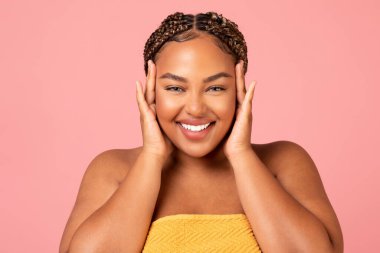 Portrait Of Happy Overweight African American Female Posing Touching Face Caring For Smooth Skin Smiling To Camera Over Pink Background. Studio Shot. Beauty And Pampering