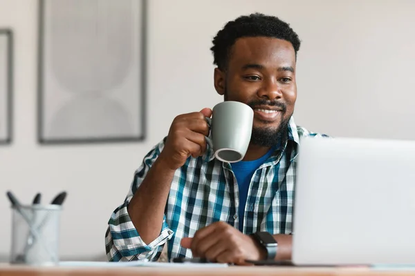 Contented Black Male Freelancer Having Coffee Using Laptop Computer Working — Stok fotoğraf