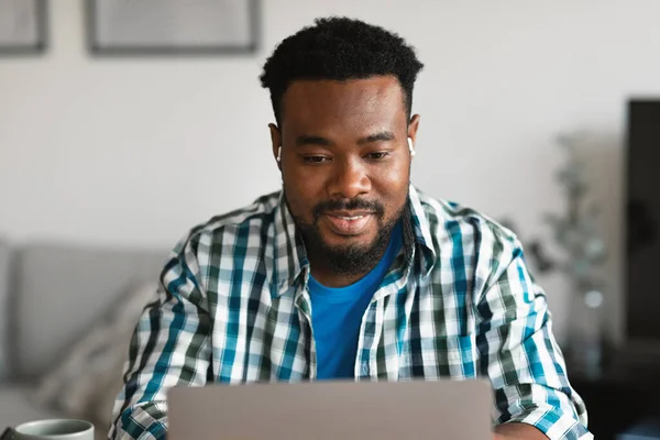 African American Freelancer Guy Using Laptop Wearing Earbuds Earphones Working —  Fotos de Stock