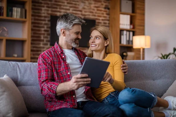 Smiling Middle Aged Caucasian Husband Wife Tablet Sit Sofa Have — Stok fotoğraf