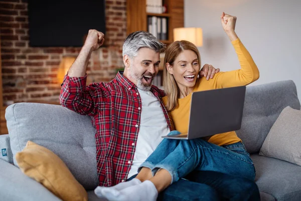 Satisfied Adult Caucasian Husband Hugging Wife Celebrating Victory Online Looking — Fotografia de Stock