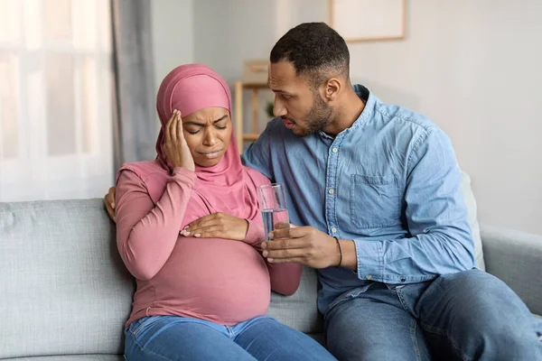 Caring Husband Giving Water Black Pregnant Muslim Wife Suffering Headache — Stockfoto