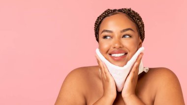 Happy Obese African American Female Caring For Skin Drying Face With Soft Towel Looking Aside Posing Over Pink Background, Studio Shot. Facial Skincare Concept. Panorama With Free Space