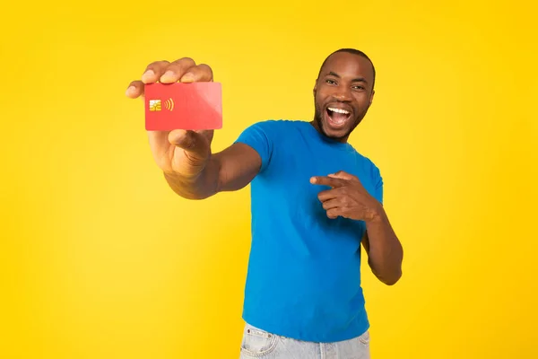 Joyful African American Man Showing Red Credit Card Pointing Finger — Fotografia de Stock