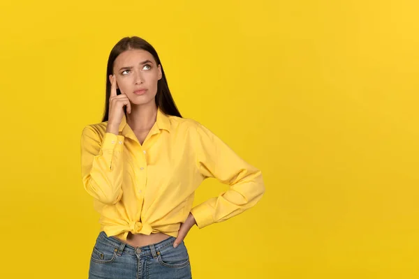 Thoughtful Millennial Lady Thinking Touching Head Looking Aside Standing Yellow — Stockfoto