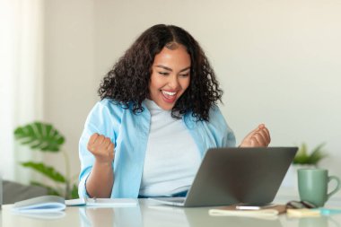 Joyful African American Businesswoman At Laptop Gesturing Yes Working Online And Celebrating Business Success Sitting In Modern Office. Successful Entrepreneur Concept. Selective Focus