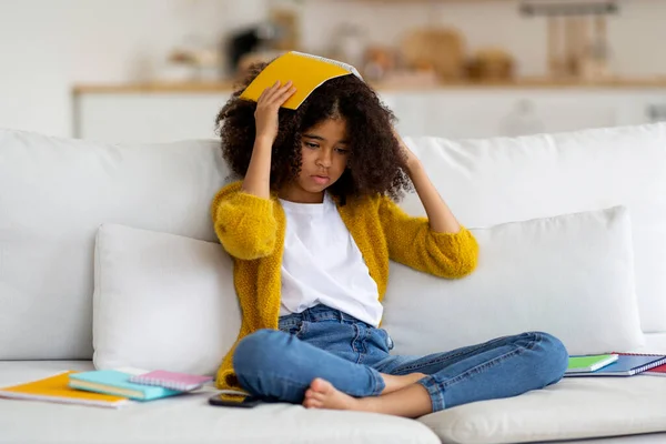 Tired African American School Girl Bushy Hair Sitting Couch Books — стокове фото