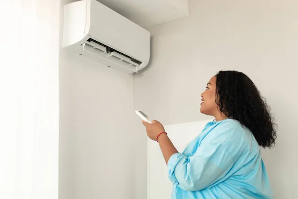 House Climate Control African American Woman Turning Air Conditioner Remote — Fotografia de Stock