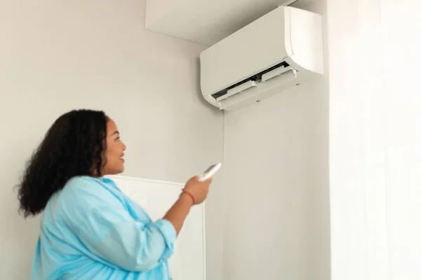 Air Conditioning System African American Female Pointing Remote Controller Turning —  Fotos de Stock