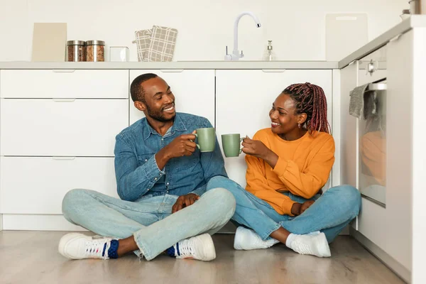 Romantic Black Couple Drinking Tea Sitting Kitchen Floor Talking Clinking — Foto de Stock