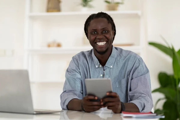 Happy Young African American Guy Using Digital Tablet While Sitting — Stockfoto