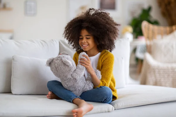 Positive Adorable African American School Girl Bushy Hair Sitting Couch — Fotografia de Stock