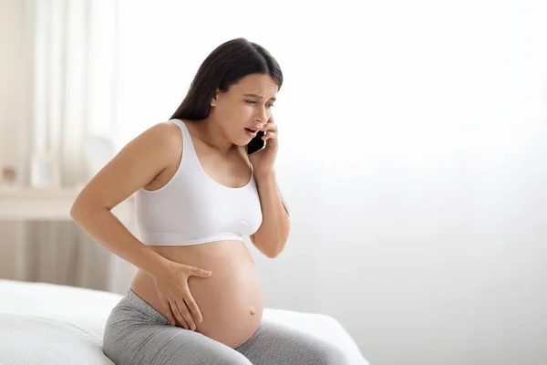 Worried Young Pregnant Woman Homewear Sitting Bed Touching Her Big — Zdjęcie stockowe