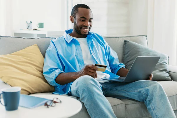 Happy African American Man Holding Credit Card Hand Using Laptop — Stok fotoğraf