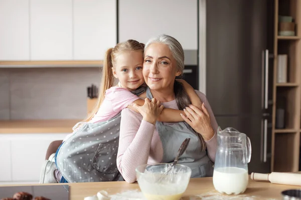 Smiling Little Girl Hugs Old Woman Apron Making Dough Kitchen — Stockfoto