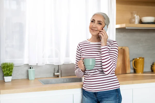 Beautiful Senior Woman Talking Mobile Phone Drinking Tea Kitchen Smiling — Foto de Stock