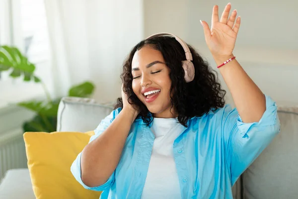 Positive Black Woman Wearing Headphones Listening Music Online Sitting Home — Foto de Stock