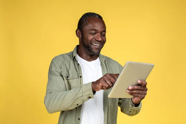 Cheerful Handsome Adult Black Man Casual Typing Tablet Reading Blog —  Fotos de Stock