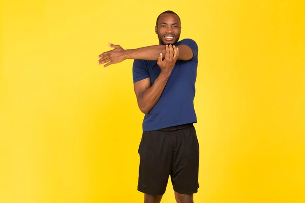 Athletic Black Guy Exercising Stretching Arms Smiling Camera Having Workout — Stockfoto