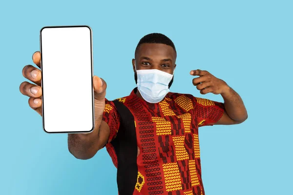 Portrait African Man Traditional Shirt Medical Mask Pointing Blank Smartphone — Fotografia de Stock