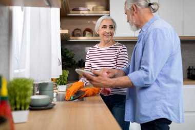 Domestic Chores. Happy Elderly Spouses Washing Dishes In Kitchen Together, Cheerful Married Senior Couple Chatting While Cleaning Plates, Enjoying Spending Time Together At Home, Copy Space
