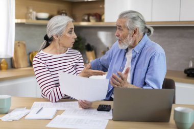 Worried Elderly Spouses Checking Financial Documents In Kitchen At Home, Stressed Senior Couple Suffering Problems While Calculating Family Budget, Having Troubles With Economy, Closeup Shot