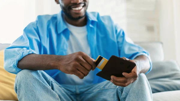 Happy African American Man Taking Credit Card Out Wallet Sitting —  Fotos de Stock