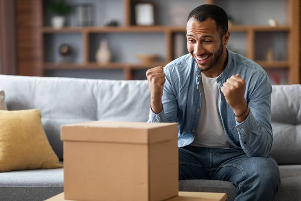 Happy Black Man Looking Cardboard Box Home Celebrating Success Excited — Φωτογραφία Αρχείου
