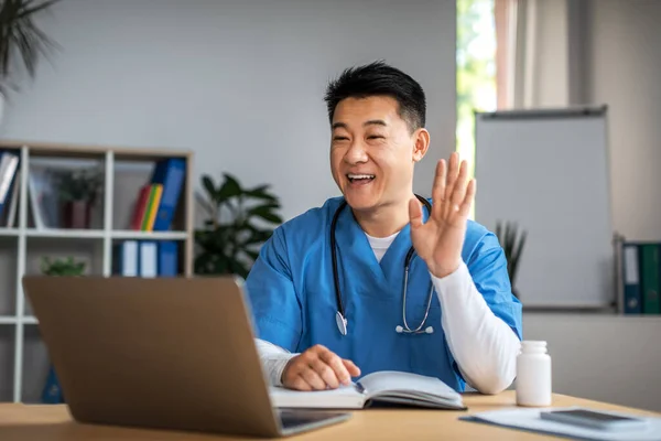 Cheerful Middle Aged Japanese Man Doctor Look Laptop Waving Hand — Stock Photo, Image