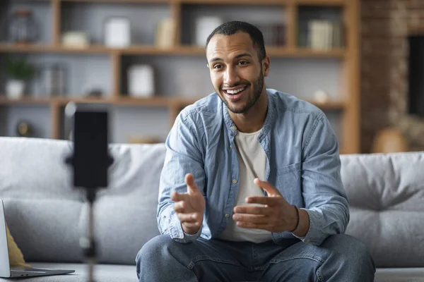 Blogging Concept. Handsome Black Man Recording Video With Smartphone On Tripod At Home, Smiling Young African American Male Capturing Content For Social Networks, Talking At Phone Camera, Copy Space