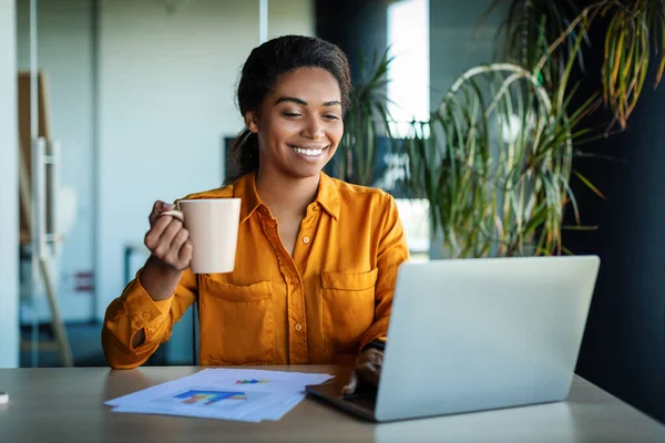 Happy African American Businesswoman Working Laptop Drinking Coffee Sitting Workplace —  Fotos de Stock