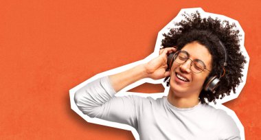 Happy curly black guy in casual using brand new wireless stereo headset, listening to music and dancing, singing songs over colorful studio background, panorama with copy space, magazine style